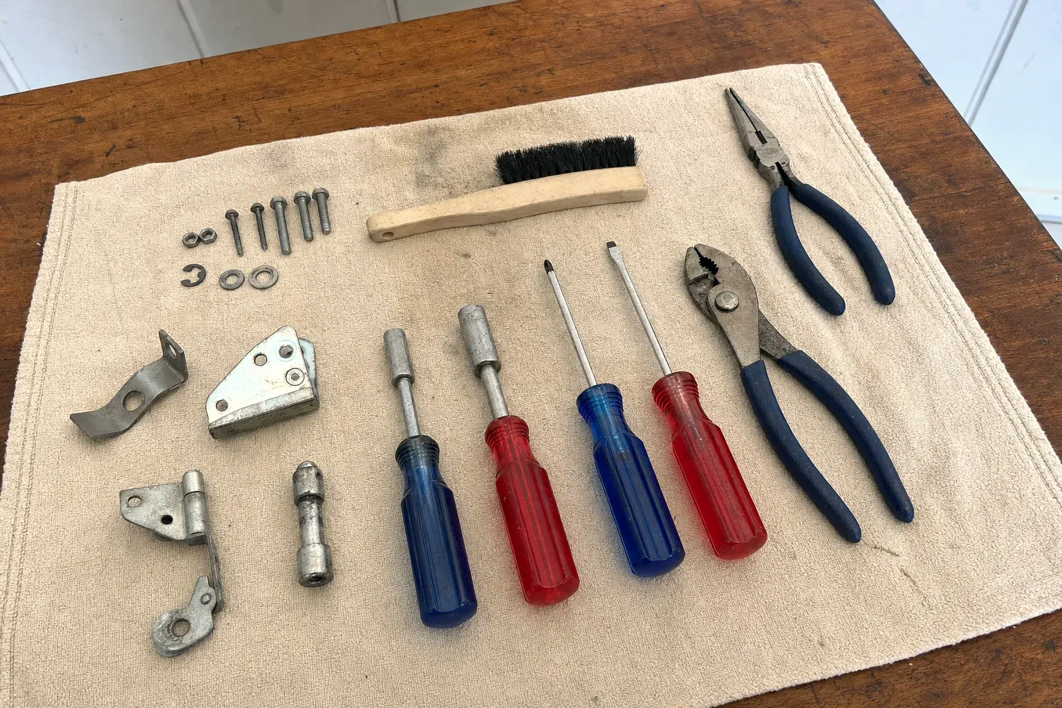 Two pliers, four screwdrivers, brush, bolts and hinge brackets