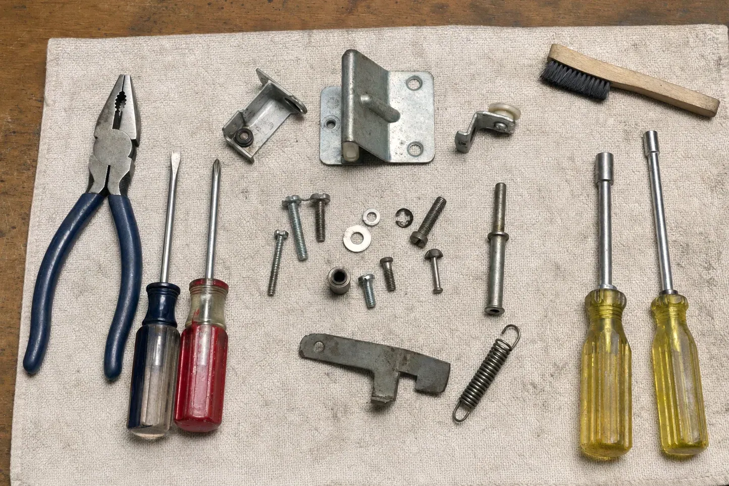 Roller, latch plate, spring, screws, nut drivers and pliers
